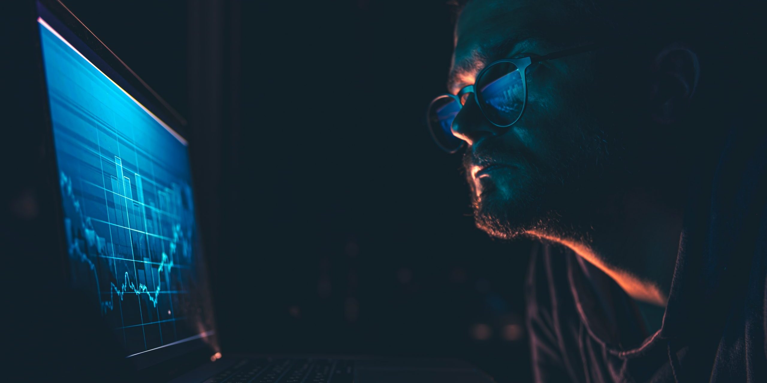 A man analyzing stock market charts, financial data on an electronic board.